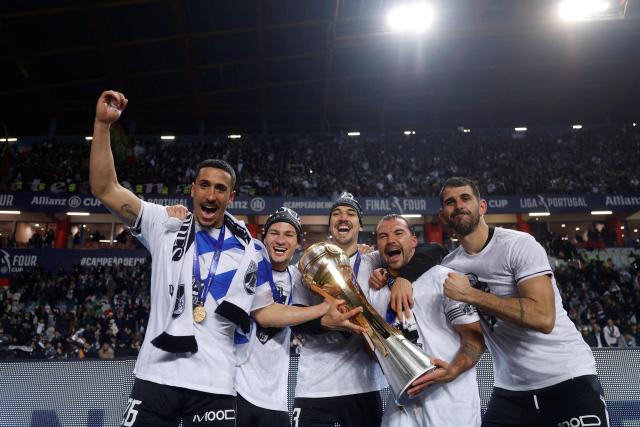 Vitoria Guimaraes's Uruguayan defender # 26 Rodrigo Abascal (L), Vitoria Guimaraes's Portuguese defender # 13 Joao Mendes (C), Vitoria Guimaraes's Portuguese midfielder # 20 Samu (2R) and teammates celebrate with the trophy after winning the Portuguese Taca da Liga (League Cup) final football match between Vitoria SC and SC Braga at the Dr. Magalhaes Pessoa stadium in Leiria, on January 10, 2026. Vitoria Guimaraes won the finale 2-1. (Photo by FILIPE AMORIM / AFP)