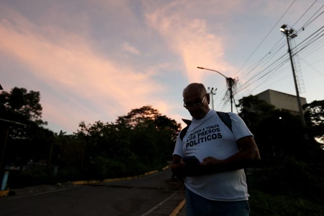 A man wears a shirt demanding freedom for political prisoners outside El Rodeo I prison in Guatire, Miranda State, some 30 kilometers east of Caracas on January 10, 2026. Venezuela on January 8 began releasing a "large number" of political prisoners, including several foreigners, in a move praised by US President Donald Trump as a step toward cooperation after the ouster of ruler Nicolas Maduro. (Photo by Pedro MATTEY / AFP)