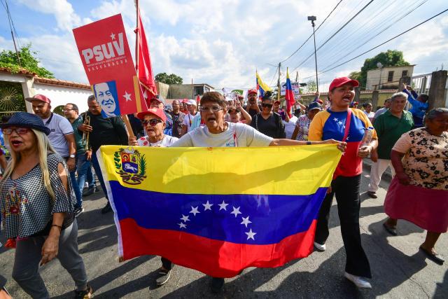 A demonstrator holding a Venezuelan flag shout slogans during a rally in support of ousted Venezuela's President Nicolas Maduro in Valencia, Carabobo state, Venezuela on January 10, 2026. The US State Department on January 10, urged Americans in Venezuela to leave the country "immediately," citing risks from armed militias searching vehicles for US citizens at roadblocks. (Photo by Jacinto OLIVEROS / AFP)