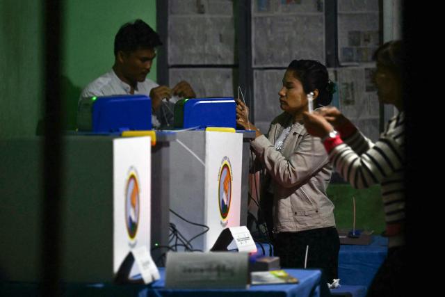 Election volunteers make final preparations before the opening of a polls for the second phase of Myanmar's general election, at a polling station at Kawhmu township in Yangon on January 11, 2026. Myanmar's junta opened polls on January 11 in the second phase of elections, continuing a vote democracy watchdogs say is letting the military prolong its rule in a civilian guise. (Photo by Sai Aung MAIN / AFP)