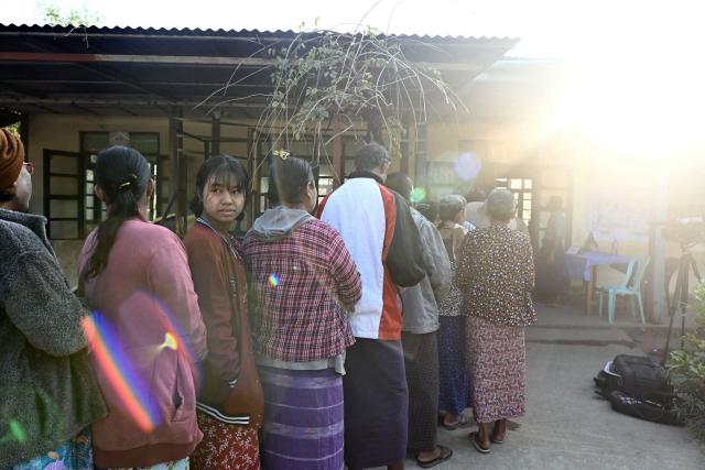 People wait in line to vote at a polling station during the second phase of Myanmar's general election at Kawhmu township in Yangon on January 11, 2026. Myanmar's junta opened polls on January 11 in the second phase of elections, continuing a vote democracy watchdogs say is letting the military prolong its rule in a civilian guise. (Photo by Sai Aung MAIN / AFP)