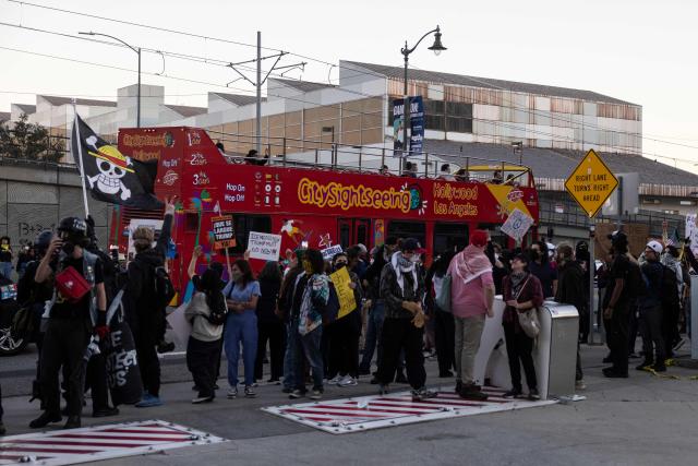 A tourist bus drives past as people protest in front of the Metropolitan Detention Center (MDC), in Los Angeles, California on January 10, 2026 against US Immigration and Customs Enforcement (ICE) after the fatal shooting of Renee Nicole Good in Minneapolis. A US Immigration and Customs Enforcement (ICE) agent shot and killed 37-year-old Renee Nicole Good on the streets of Minneapolis on January 7, leading to huge protests and outrage from local leaders who rejected White House claims she was a domestic terrorist. (Photo by ETIENNE LAURENT / AFP)