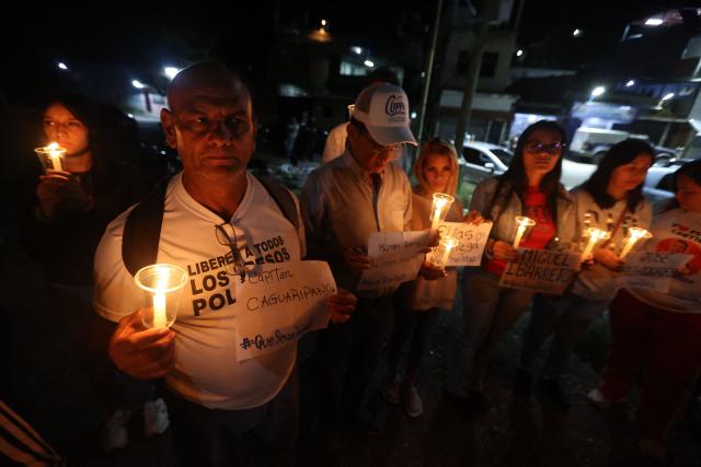 Relatives of political prisoners lit candles during a vigil outside El Rodeo I prison in Guatire, Miranda State, some 30 kilometers east of Caracas on January 10, 2026. Venezuela on January 8 began releasing a "large number" of political prisoners, including several foreigners, in a move praised by US President Donald Trump as a step toward cooperation after the ouster of ruler Nicolas Maduro. (Photo by Pedro MATTEY / AFP)
