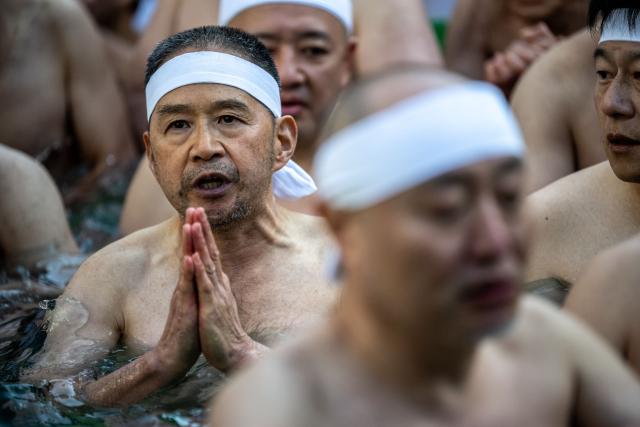 Participants take a bath in cold water to purify their souls and bodies during a New Year ritual at the Teppozu Inari Shrine in Tokyo on January 11, 2026. (Photo by Philip FONG / AFP)