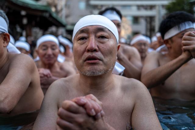 Participants take a bath in cold water to purify their souls and bodies during a New Year ritual at the Teppozu Inari Shrine in Tokyo on January 11, 2026. (Photo by Philip FONG / AFP)