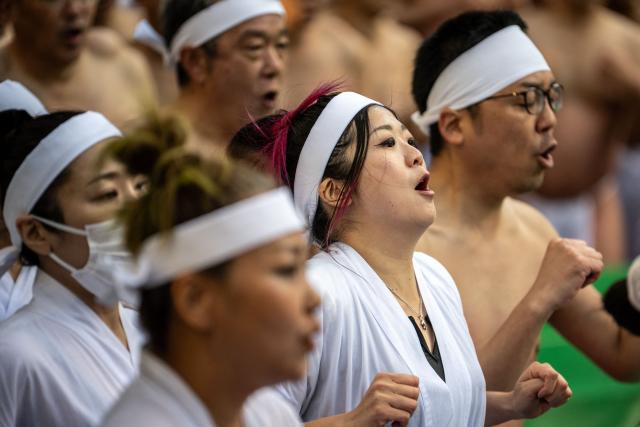 Participants exercise after a bath in cold water to purify their souls and bodies during a New Year ritual at the Teppozu Inari Shrine in Tokyo on January 11, 2026. (Photo by Philip FONG / AFP)