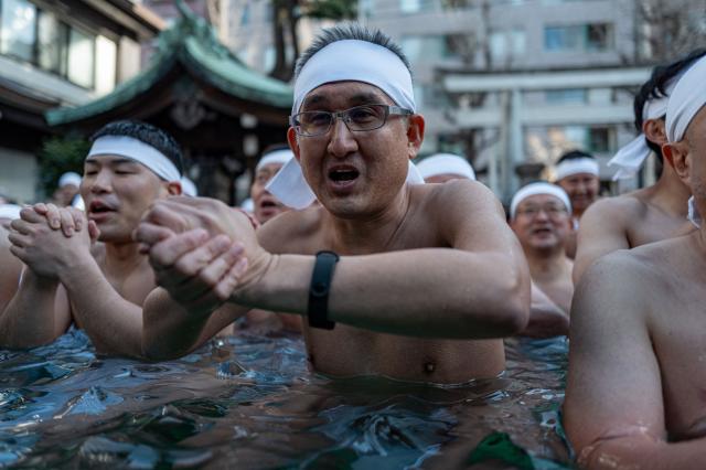 TOPSHOT - Participants take a bath in cold water to purify their souls and bodies during a New Year ritual at the Teppozu Inari Shrine in Tokyo on January 11, 2026. (Photo by Philip FONG / AFP)