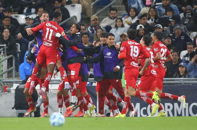 Toluca's Brazilian midfielder #11 Helinho celebrates with teammates after scoring the opening goal during the Liga MX Clausura football match between Monterrey and Toluca at BBVA Stadium in Monterrey, Nuevo Leon state, Mexico on January 10, 2026. (Photo by Julio Cesar AGUILAR / AFP)