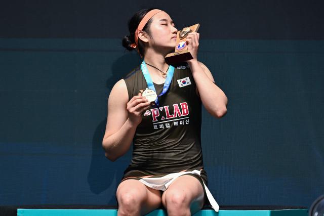 Gold medallist South Korea’s An Se-young poses with her trophy during the award ceremony for the women’s singles final match at the Malaysia Open badminton tournament in Kuala Lumpur on January 11, 2026. (Photo by MOHD RASFAN / AFP)