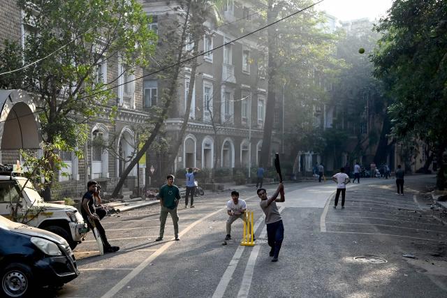 Youngsters play cricket on a deserted road during morning hours in Mumbai on January 11, 2026. (Photo by Punit PARANJPE / AFP)