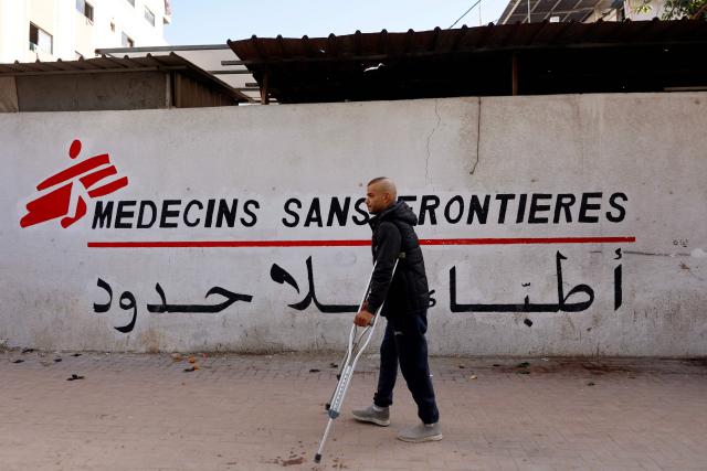 (FILES) A Palestinian man walks on his crutches to the Doctors Without Borders or Medecins Sans Frontieres (MSF) clinic, in the al-Rimal neighborhood of Gaza City on new year's Eve, December 31, 2025. Banned from the Gaza Strip with 36 aid bodies, medical charity Doctors Without Borders said Saturday it will have to end its operations there in March if Israel does not reverse its decision. UN secretary general Antonio Guterres called on January 9, 2026, for Israel to end a ban on humanitarian agencies that provided aid in Gaza, saying he was "deeply concerned" at the development. (Photo by Omar AL-QATTAA / AFP)