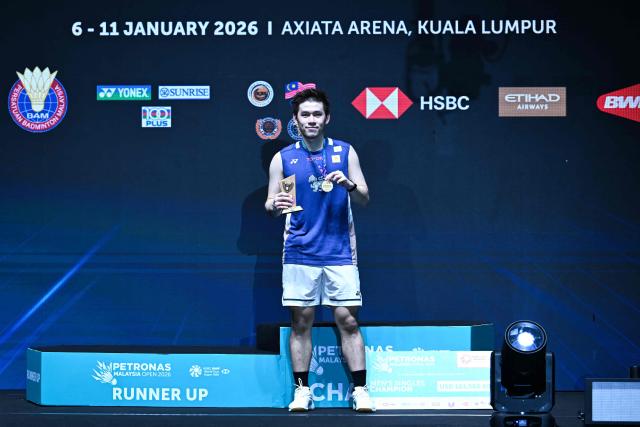 Gold medallist Thailand’s Kunlavut Vitidsarn poses with his trophy during the awards ceremony after the men’s single final match against China's Shi Yuqi at the Malaysia Open badminton tournament in Kuala Lumpur on January 11, 2026. (Photo by MOHD RASFAN / AFP)