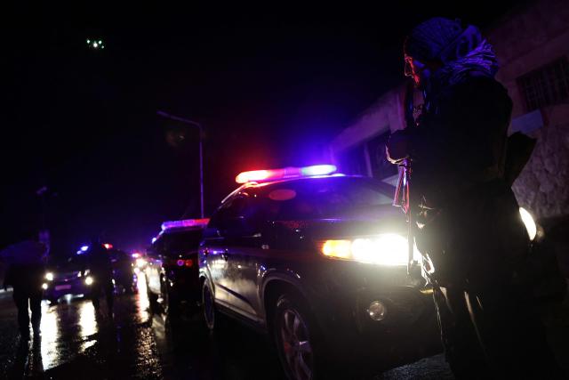 A Syrian security force officer stands guard as six buses and Syrian Arab Red Crescent ambulances carrying Kurds are escorted as they leave the Kurdish-majority Sheikh Maqsud neighbourhood, in the city of Aleppo, northern Syria early on January 11, 2026. The Kurdish-led Syrian Democratic Forces (SDF) said January 11, 2026, that they agreed under a ceasefire to withdraw their fighters from the two districts they held in Aleppo after deadly clashes in the city. "We reached an understanding that led to a ceasefire and secured the evacuation of the martyrs, the wounded, the trapped civilians and the fighters from Ashrafiyeh and Sheikh Maqsud neighbourhoods to northern and eastern Syria," the SDF wrote in a statement. Syria's official SANA news agency reported that "buses carrying the last batch of members of the SDF organisation have left the Sheikh Maqsud neighbourhood in Aleppo, heading towards northeastern Syria." (Photo by Bakr ALkasem / AFP)