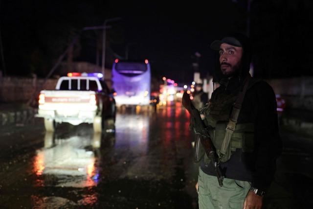 A Syrian security force officer stands guard as six buses and ambulances of the Syrian Arab Red Crescent carrying Kurds are escorted as they leave the Kurdish-majority Sheikh Maqsud neighbourhood, in the city of Aleppo, northern Syria early on January 11, 2026. The Kurdish-led Syrian Democratic Forces (SDF) said January 11, 2026, that they agreed under a ceasefire to withdraw their fighters from the two districts they held in Aleppo after deadly clashes in the city. "We reached an understanding that led to a ceasefire and secured the evacuation of the martyrs, the wounded, the trapped civilians and the fighters from Ashrafiyeh and Sheikh Maqsud neighbourhoods to northern and eastern Syria," the SDF wrote in a statement. Syria's official SANA news agency reported that "buses carrying the last batch of members of the SDF organisation have left the Sheikh Maqsud neighbourhood in Aleppo, heading towards northeastern Syria." (Photo by Bakr ALkasem / AFP)