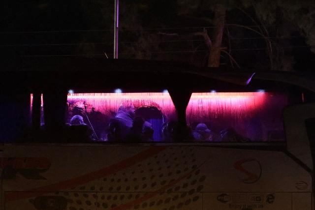Kurdish men sit in a bus as government Syrian security forces escort six buses as they leave the Kurdish-majority Sheikh Maqsud neighbourhood, in the city of Aleppo, northern Syria early on January 11, 2026. The Kurdish-led Syrian Democratic Forces (SDF) said January 11, 2026, that they agreed under a ceasefire to withdraw their fighters from the two districts they held in Aleppo after deadly clashes in the city. "We reached an understanding that led to a ceasefire and secured the evacuation of the martyrs, the wounded, the trapped civilians and the fighters from Ashrafiyeh and Sheikh Maqsud neighbourhoods to northern and eastern Syria," the SDF wrote in a statement. Syria's official SANA news agency reported that "buses carrying the last batch of members of the SDF organisation have left the Sheikh Maqsud neighbourhood in Aleppo, heading towards northeastern Syria." (Photo by Bakr ALkasem / AFP)