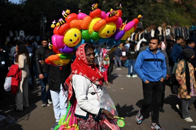 A vendor selling toys and inflated balloons looks for customers at a marketplace in New Delhi on January 11, 2026. (Photo by Sajjad HUSSAIN / AFP)