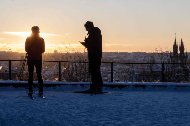 A man and a woman on cross-country skis take a view over Prague during a sunrise on January 11, 2026, as the temperatures dropped to minus 11 degrees Celsius in the Czech capital. (Photo by Michal Cizek / AFP)