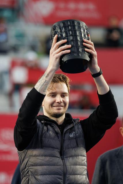 Kazakhstan's Alexander Bublik celebrates with the trophy after his victory against Italy's Lorenzo Musetti during the men's singles final at the Hong Kong Tennis Open in Hong Kong on January 11, 2026. (Photo by May JAMES / AFP)