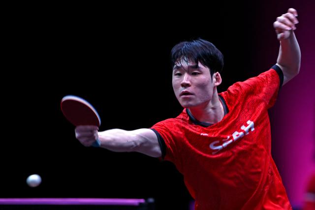 South Korea's Jang Woojin returns the ball against China’s Lin Shidong during their men's singles semi-final match during the World Table Tennis (WTT) Champions tournament at the Infinity Arena in Doha on January 11, 2026. (Photo by MAHMUD HAMS / AFP)
