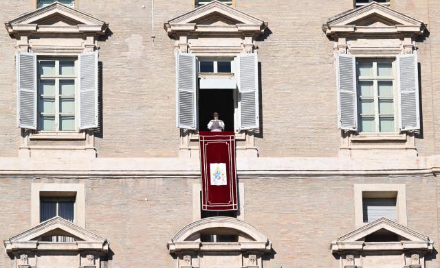 Pope Leo XIV addresses the crowd from the window of the apostolic palace overlooking St.Peter's square during his Sunday Angelus prayer at the Vatican on January 11, 2026. (Photo by Alberto PIZZOLI / AFP)