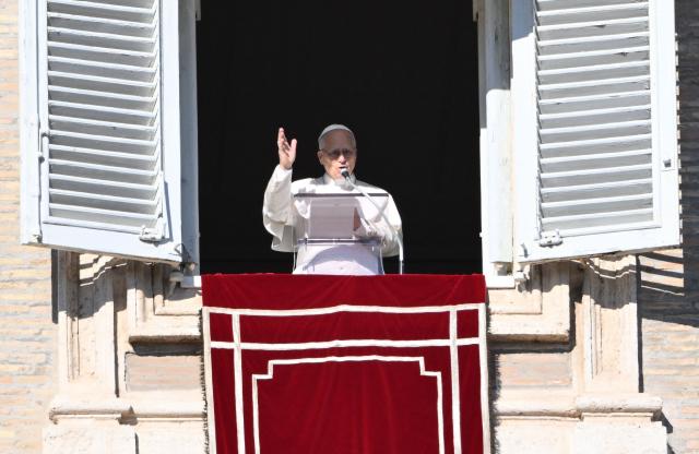 Pope Leo XIV addresses the crowd from the window of the apostolic palace overlooking St.Peter's square during his Sunday Angelus prayer at the Vatican on January 11, 2026. (Photo by Alberto PIZZOLI / AFP)