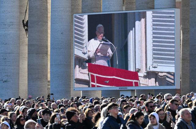 A giant screen shows Pope Leo XIV adressing the crowd from the window of the apostolic palace overlooking St.Peter's square during his Sunday Angelus prayer at the Vatican on January 11, 2026. (Photo by Alberto PIZZOLI / AFP)