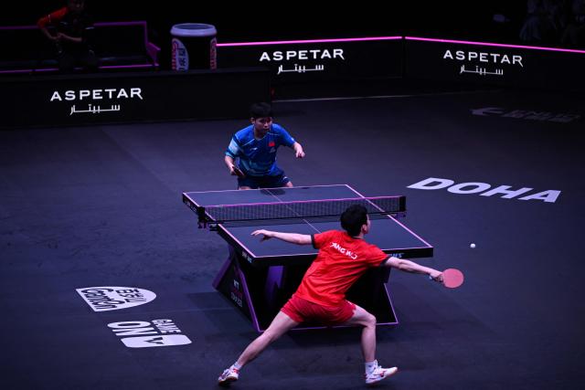 China’s Lin Shidong (top) plays against South Korea's Jang Woojin during their men's singles semi-final match during the World Table Tennis (WTT) Champions tournament at the Infinity Arena in Doha on January 11, 2026. (Photo by MAHMUD HAMS / AFP)