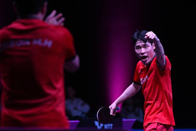 South Korea's Jang Woojin reacts after beating China’s Lin Shidong during their men's singles semi-final match during the World Table Tennis (WTT) Champions tournament at the Infinity Arena in Doha on January 11, 2026. (Photo by MAHMUD HAMS / AFP)