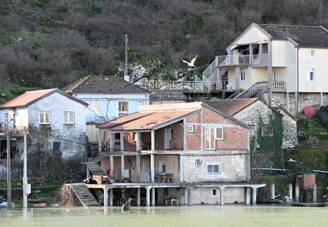 This photograph shows flooded houses in the fishermen's village of Vranjina, on the shores of Skadar lake, 25km South of Montenegro's capital of Podgorica, on January 11, 2026. Water level at Skadar lake has risen after heavy rain hit the area, causing a massive overflow on artificial lakes in neighboring Albania. (Photo by SAVO PRELEVIC / AFP)