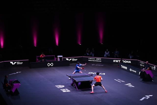 Japan's Tomokazu Harimoto (top) hits a return against Taiwan's Lin Yun-ju during their men's singles semi-final match during the World Table Tennis (WTT) Champions tournament at the Infinity Arena in Doha on January 11, 2026. (Photo by Mahmud HAMS / AFP)