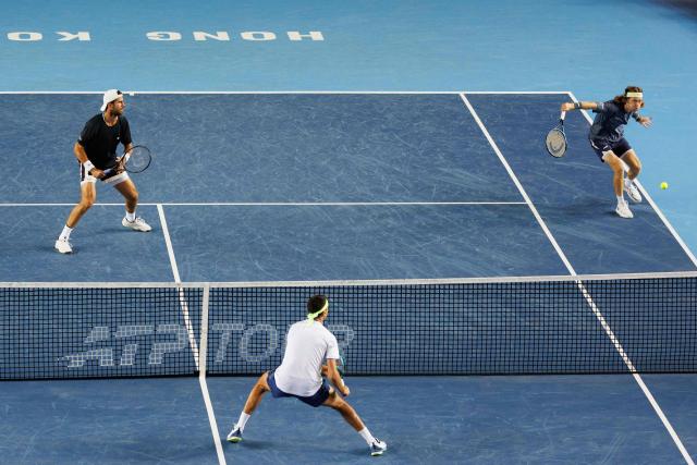 Russia's Andrey Rublev (R) and Karen Khachanov (L) hit a return against Italy's Lorenzo Sonego (C) and Lorenzo Musetti during their men's doubles final match at the Hong Kong Tennis Open in Hong Kong on January 11, 2026. (Photo by May JAMES / AFP)