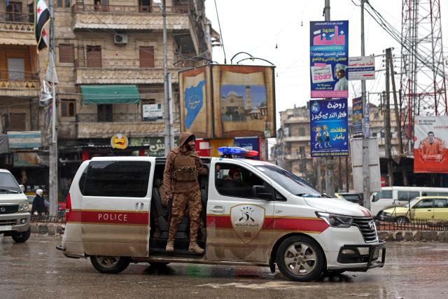 Syrian security officers patrol the streets following a ceasefire in the Kurdish-majority Ashrafiyeh neighbourhood of the city of Aleppo, northern Syria on January 11, 2026. Syria's Kurdish fighters said on January 11, 2026, that they agreed under a ceasefire to withdraw after days of fighting government forces in the city. The latest clashes erupted after negotiations to integrate the Kurds into the country's new government stalled. (Photo by OMAR HAJ KADOUR / AFP)