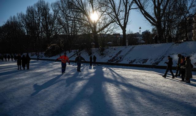 People skate on the ice covering the Neukoelln Ship Canal in Berlin's Treptow district in Berlin on January 11, 2026, as the capital continued to experience sub-zero degrees centigrade. (Photo by John MACDOUGALL / AFP)