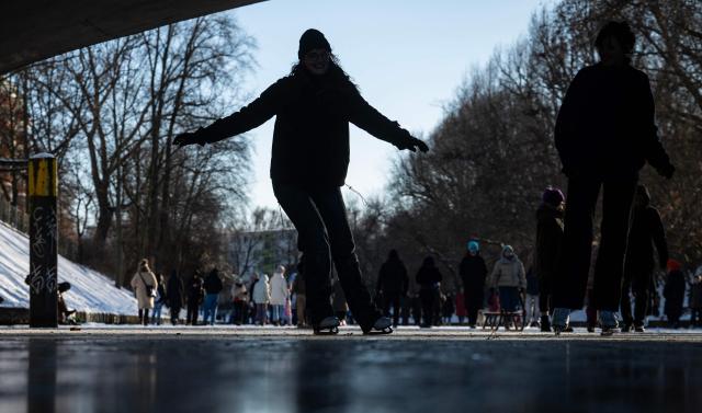 People skate on the ice covering the Neukoelln Ship Canal in Berlin's Treptow district in Berlin on January 11, 2026, as the German capital continued to experience sub-zero degrees centigrade. (Photo by John MACDOUGALL / AFP)