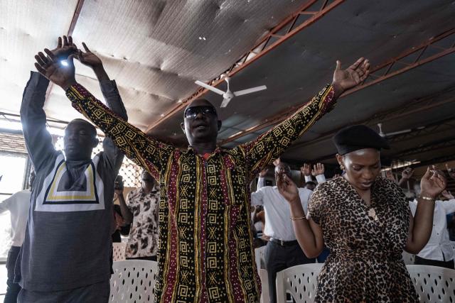 Christian worshippers raise their hands as they praise and pray for a peaceful election at Victory church in Kampala, on January 11, 2026, ahead of the 2026 Ugandan general election. (Photo by Badru Katumba / AFP)