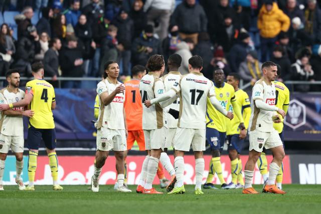 Lens’ players celebrate after winning the French Cup round of 32 football match between FC Sochaux-Montbeliard and RC Lens at the Auguste-Bonal stadium in Sochaux, eastern France on January 11, 2026. (Photo by Frederick FLORIN / AFP)