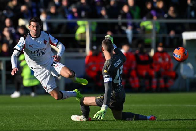 AC Milan's US forward #11 Christian Pulisic (L) shoots past Fiorentina’s Spanish goalkeeper #43 David de Gea during the Italian Serie A football match between ACF Fiorentina and AC Milan at Artemio Franchi stadium in Florence on January 11, 2026. (Photo by Andreas SOLARO / AFP)