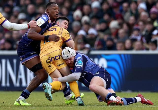Northampton Saints' French fly-half Anthony Belleau (C) is tackled by Bordeaux-Begles' French lock Cameron Woki (L) and Bordeaux-Begles' French hooker Maxime Lamothe (R) during the European Champions Cup first round, day 3, pool 4, rugby union match between Bordeaux-Begles and Northampton Saints at the Chaban-Delmas stadium in Bordeaux on January 11, 2026. (Photo by ROMAIN PERROCHEAU / AFP)
