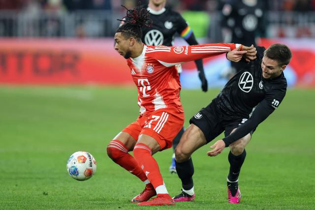 Bayern Munich's French midfielder #17 Michael Olise (L) and Wolfsburg's German defender #02 Kilian Fischer vie for the ball during the German first division Bundesliga football match between FC Bayern Munich and VfL Wolfsburg in Munich, southern Germany, on January 11, 2026. (Photo by Alexandra BEIER / AFP) / DFL REGULATIONS PROHIBIT ANY USE OF PHOTOGRAPHS AS IMAGE SEQUENCES AND/OR QUASI-VIDEO
