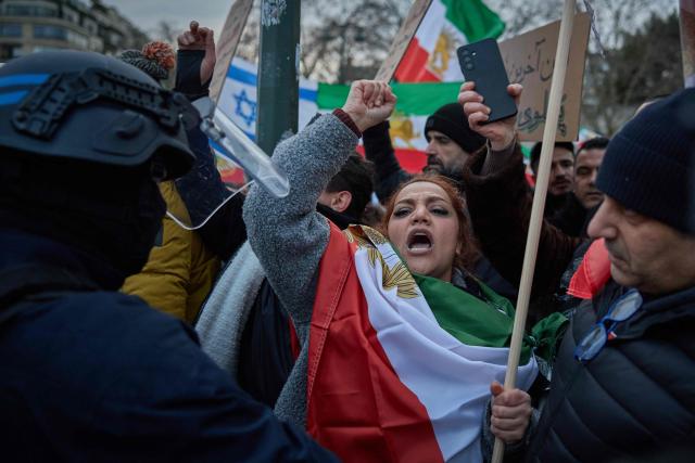 Police hold back protestors at Place de la Trocadéro during a demonstration to support mass rallies denouncing the Islamic republic in Iran in Paris on January 11, 2026. At least 192 protesters have been killed in Iran's biggest movement against the Islamic republic in more than three years, as warnings grew that authorities were committing a "massacre" to quell the demonstrations. The protests, initially sparked by anger over the rising cost of living, have now become a movement against the theocratic system in place in Iran since the 1979 revolution and have already lasted two weeks. (Photo by Kiran RIDLEY / AFP)