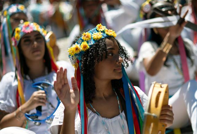 Revellers perform during the traditional Reinado de Nossa Senhora do Rosario, Santa Efigenia e Sao Benedito (Reign of Our Lady of the Rosary, St Efigenia and St. Benedict) festival to honour Chico Rei, through the historic streets of Ouro Preto, Brazil, on January 11, 2026. According to tradition, Chico was the king of a tribe in Congo brought by the Portuguese as a slave and who managed to buy his freedom and that of other slaves to become 'king' in Ouro Preto and, from then on, part of the Brazilian folklore. More than 30 congado guards from Ouro Preto and the region take part in the event. (Photo by Douglas MAGNO / AFP)