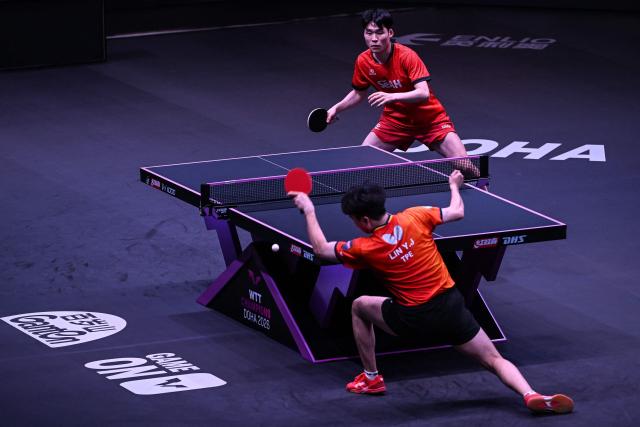 South Korea's Jang Woojin (top) hits a return against Taiwan's Lin Yun-ju during their men's singles final match in the World Table Tennis (WTT) Champions tournament at the Infinity Arena in Doha on January 11, 2026. (Photo by Mahmud HAMS / AFP)