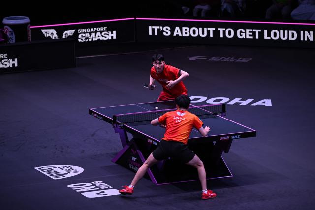 South Korea's Jang Woojin (top) hits a return against Taiwan's Lin Yun-ju during their men's singles final match in the World Table Tennis (WTT) Champions tournament at the Infinity Arena in Doha on January 11, 2026. (Photo by Mahmud HAMS / AFP)