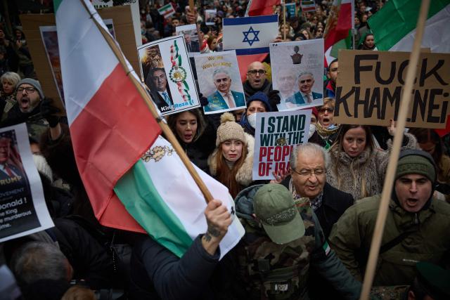 Protestors carry placards with the image of Iranian opposition leader and son of the last shah of Iran Mohammad Reza Pahlavi, Reza Pahlavi, during a demonstration to support mass rallies denouncing the Islamic republic in Iran in Paris on January 11, 2026. At least 192 protesters have been killed in Iran's biggest movement against the Islamic republic in more than three years, as warnings grew that authorities were committing a "massacre" to quell the demonstrations. The protests, initially sparked by anger over the rising cost of living, have now become a movement against the theocratic system in place in Iran since the 1979 revolution and have already lasted two weeks. (Photo by Kiran RIDLEY / AFP)