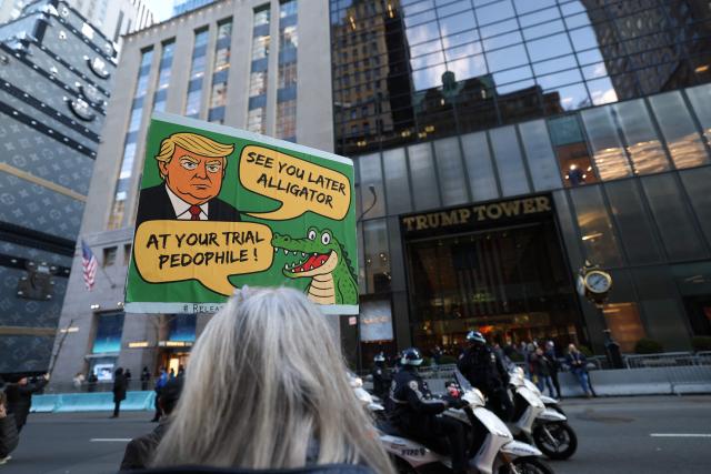 A person holds a sign outside the Trump tower during a protest organized by Rise and Resist against US Immigration and Customs Enforcement (ICE) activities and the US intervention in Venezuela in New York on January 11, 2026. (Photo by TIMOTHY A. CLARY / AFP)