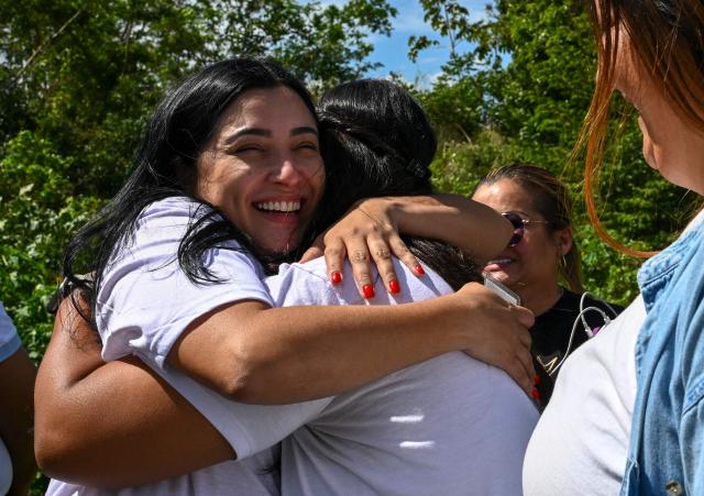 Relatives of inmates hug each other while waiting for news on the release of prisoners, outside El Rodeo I prison in Guatire, Miranda State, some 30 kilometers east of Caracas on January 11, 2026. Venezuelans were waiting for more political prisoners to be released on Sunday, as ousted president Nicolas Maduro defiantly claimed from his US jail cell that he is "doing fine" after being seized by US forces a week ago. (Photo by Ronaldo SCHEMIDT / AFP)