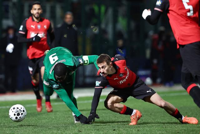 US Chantilly's French forward #09 Dramane Koné (L) fights fort the ball with Rennes' French midfielder #06 Valentin Rongier (R) during the French Cup round of 16 football match between Chantilly and Rennes at the Pierre-Brisson stadium in Beauvais, France on January 11, 2026. (Photo by Anne-Christine POUJOULAT / AFP)