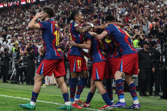 Barcelona's Polish forward #09 Robert Lewandowski celebrates with teammates after scoring his team's second goal during the Spanish Super Cup final football match between FC Barcelona and Real Madrid at the King Abdullah Stadium in Jeddah on January 11, 2026. (Photo by Fadel SENNA / AFP)