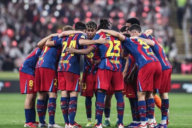 Barcelona's players stand in a group before the second half time during the Spanish Super Cup final football match between FC Barcelona and Real Madrid at the King Abdullah Stadium in Jeddah on January 11, 2026. (Photo by Fadel SENNA / AFP)