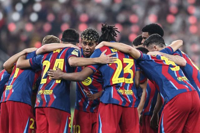 Barcelona's players stand in a group before the second half time during the Spanish Super Cup final football match between FC Barcelona and Real Madrid at the King Abdullah Stadium in Jeddah on January 11, 2026. (Photo by Fadel SENNA / AFP)